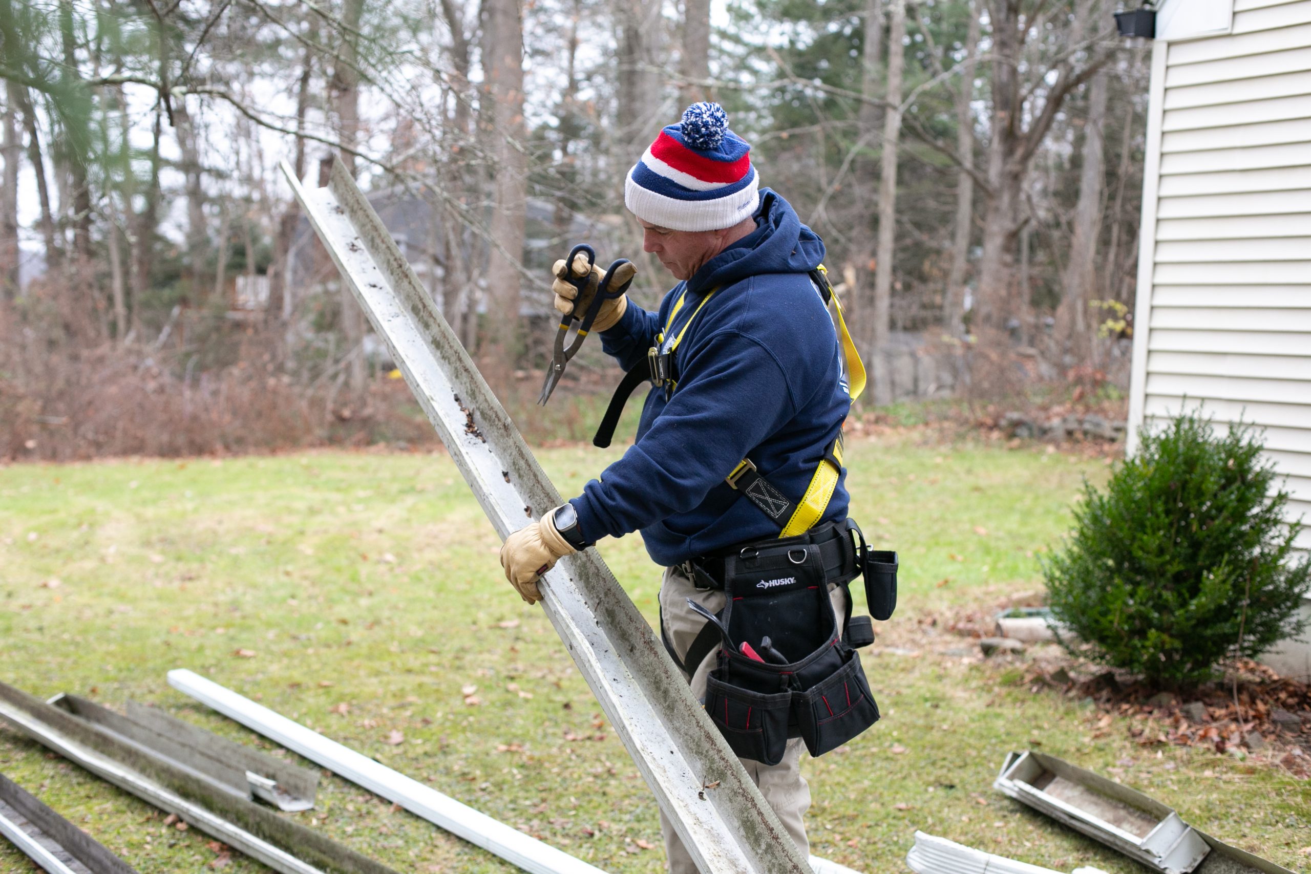 Gutter repair services - A worker performs and exam on a gutter to determine its use
